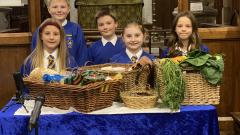 Children in All Saints' Church Ripley standing at the alter with Harvest Festival offerings